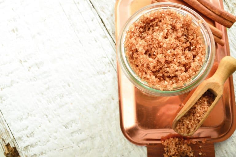 brown sugar with cinnamon body scrub in a glass bowl on top of a copper serving plate. Does Body Scrub Clog Drains