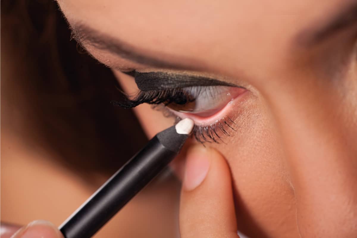 girl applying white eyeliner