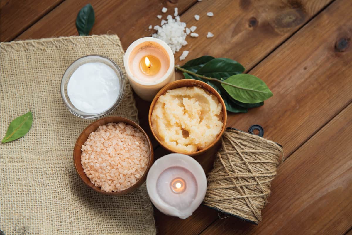 natural body scrub and candles on wood