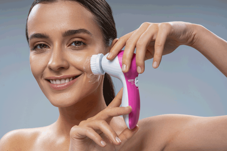 A woman cleaning her face with a face cleanser brush, How To Use A Face Cleanser Brush
