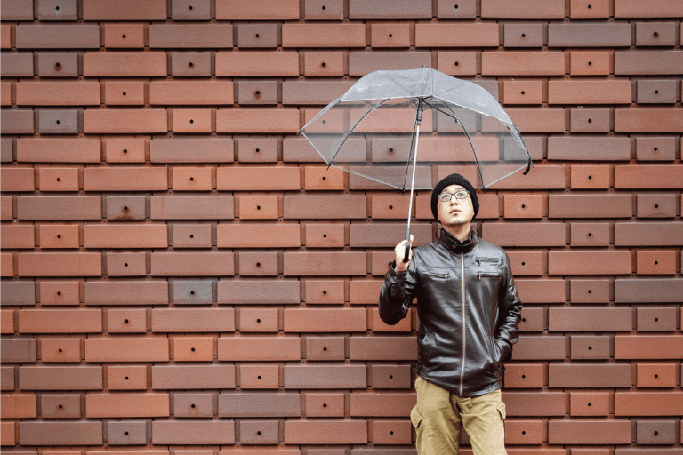An Asian Man in a Brown Jacket With a Clear Umbrella. Are Leather Jackets Waterproof