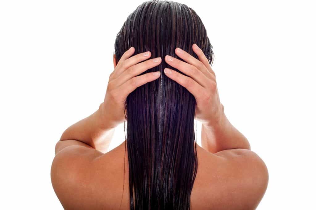 Back view of woman with long wet hair on white background