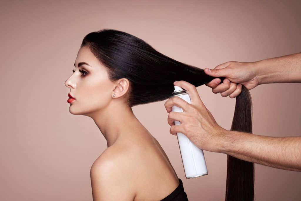 Парикмахер укладывает женские волосы.  Портрет красивой молодой женщины, получающей стрижку