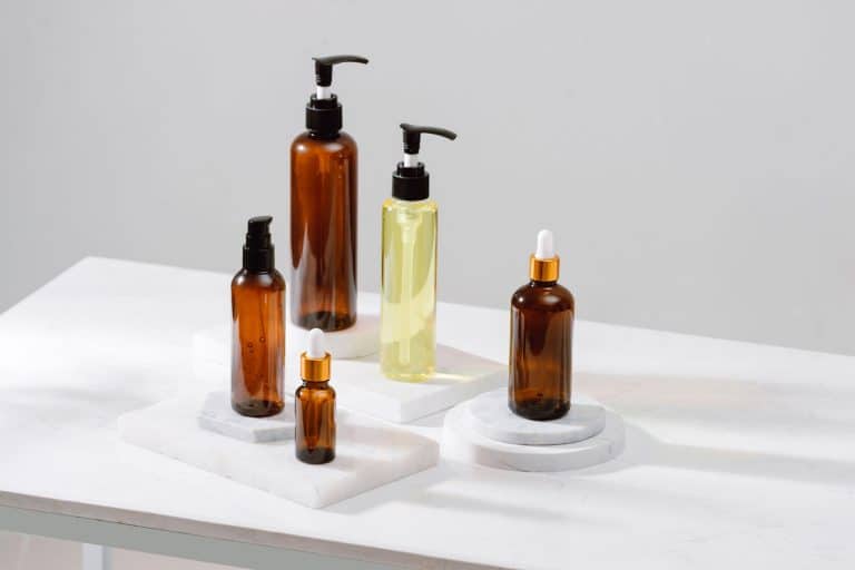 Spa cosmetics in brown glass bottles on gray concrete table