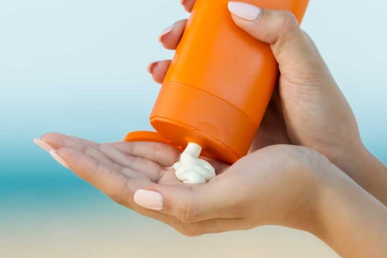 Woman hand apply sunscreen on the beach, 10 Best Moisturizer With Sunscreen For Oily Skin