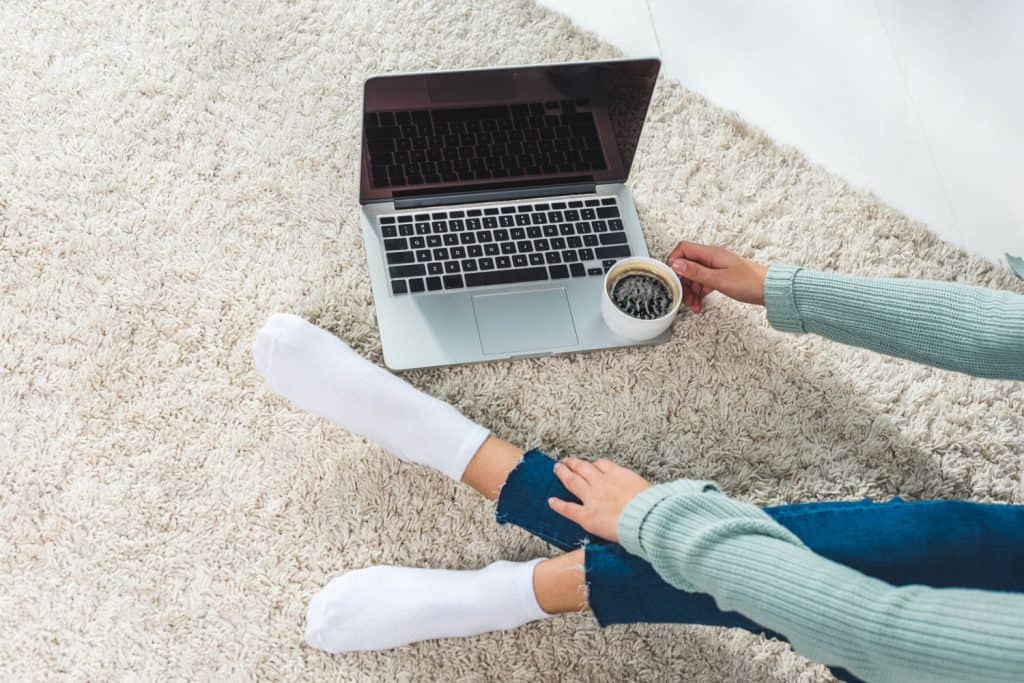 Young woman with laptop at home wearing white socks