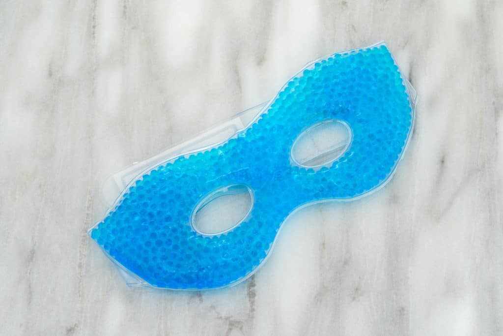 A gel bead eye mask placed on a bed