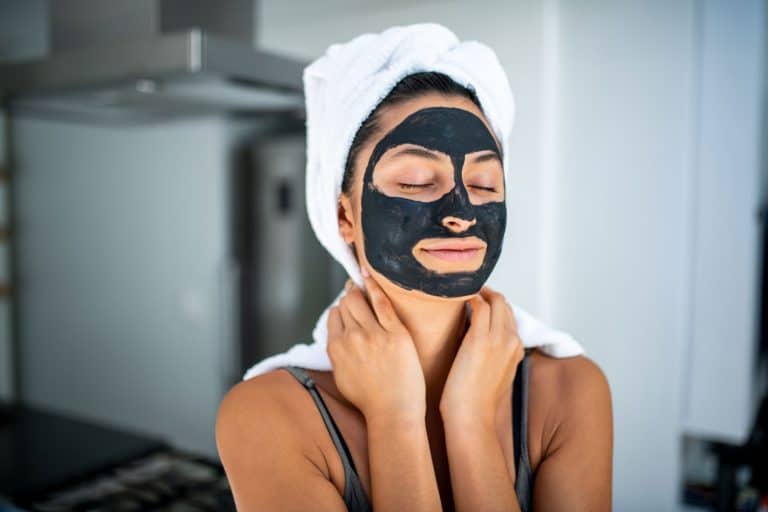 A woman applying clay mask on her face on spa day, How Much Of A Clay Mask Should You Apply?