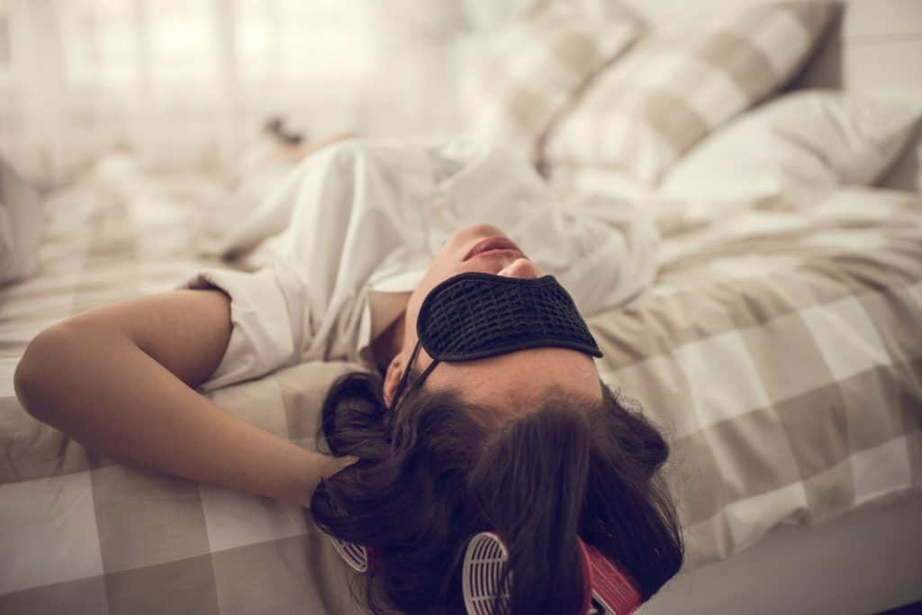 A woman sleeping with an eye mask on 