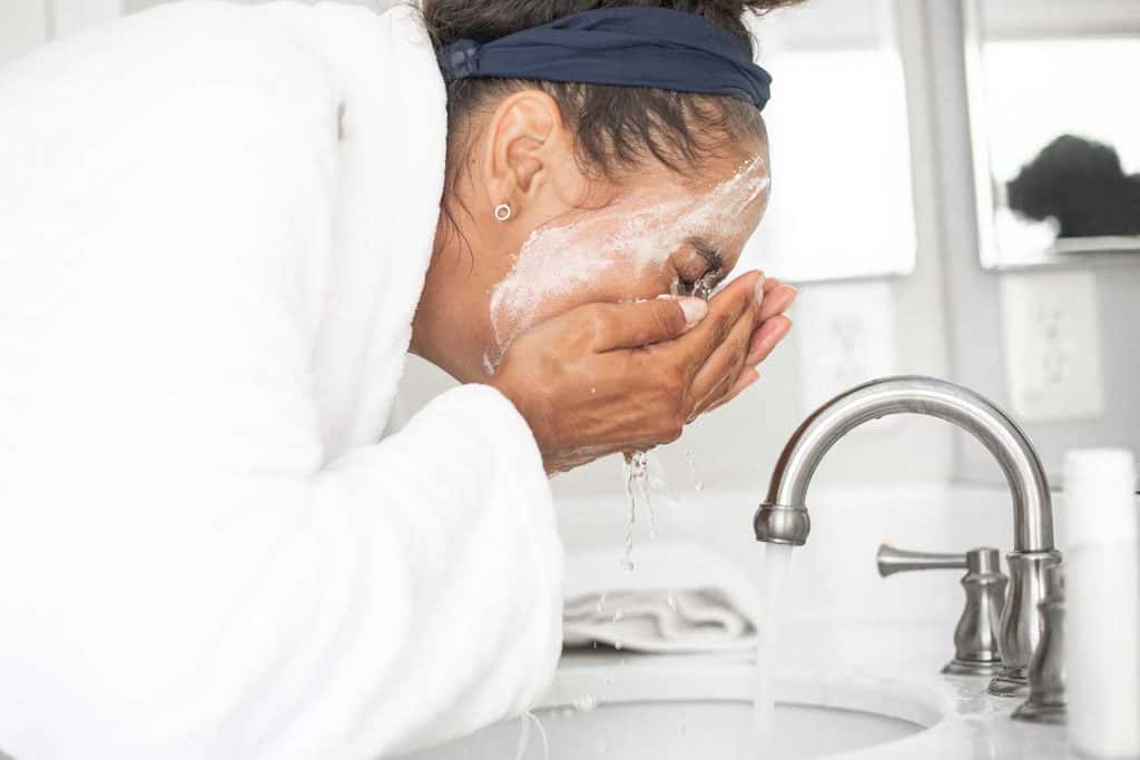 A young woman washing her face in the bathroom