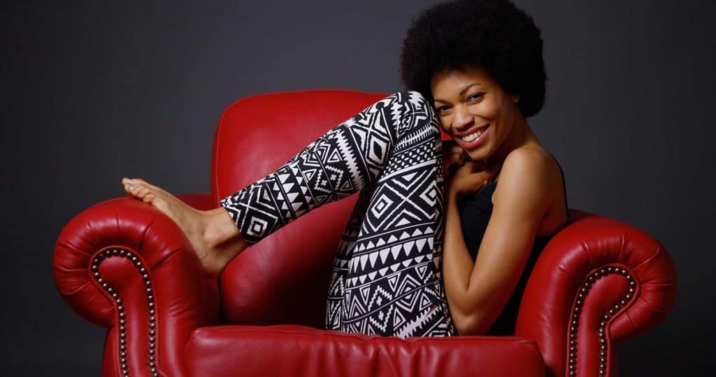 African woman sitting in red armchair