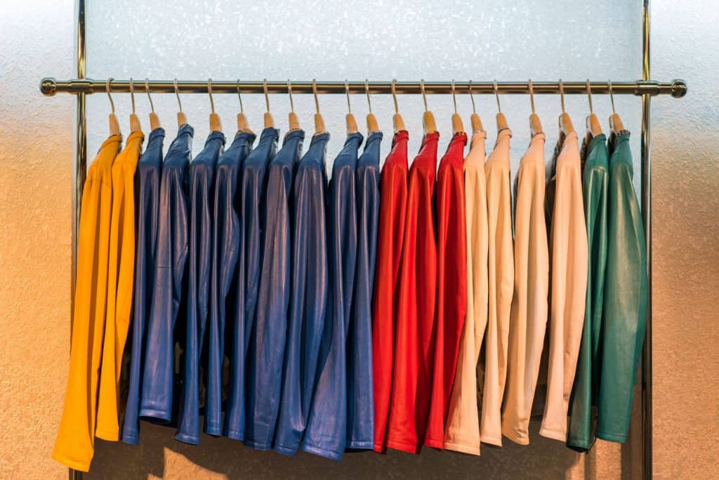 Colored leather jackets in a variety of different colors hanging up in a row on the rail,Should You Hang A Leather Jacket?