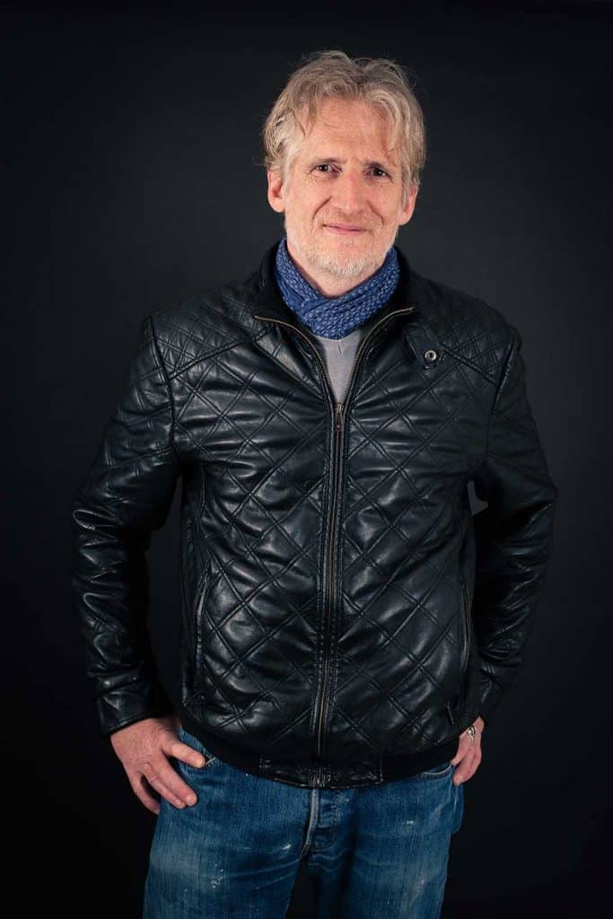 Handsome adult man wearing blue scarf, jeans and black leather jacket