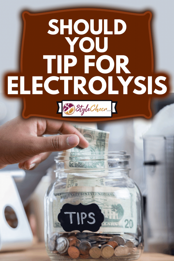 Unrecognizable male customer places cash into a tip jar, Should You Tip For Electrolysis?