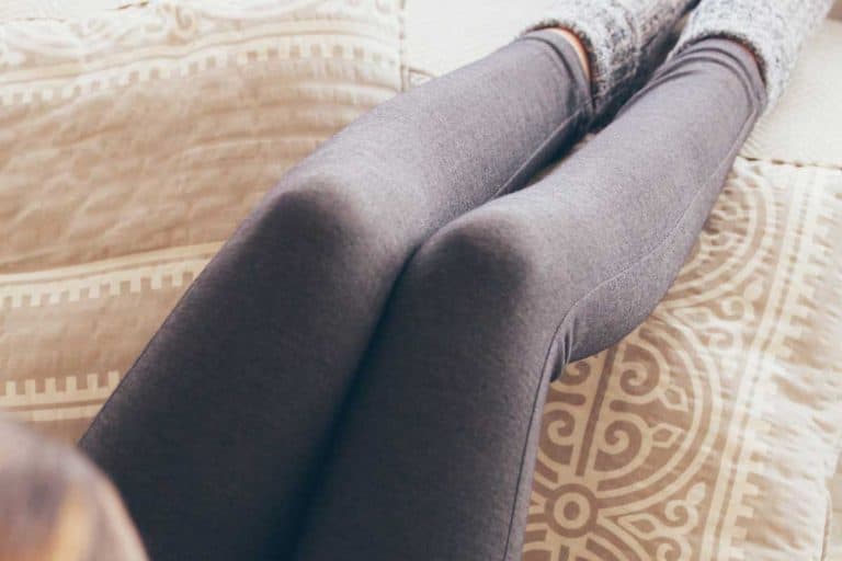 Young woman in leggings drinking coffee sitting on the sofa, How To Get Rid Of Pilling And Fuzzies On Leggings