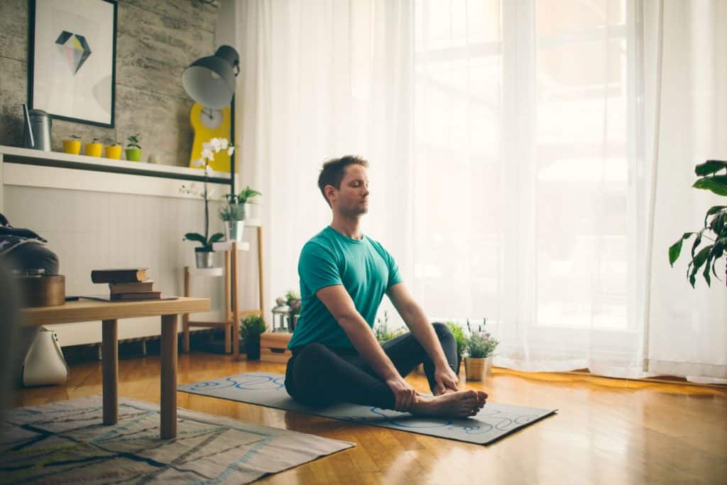 A man doing some yoga work inside his home