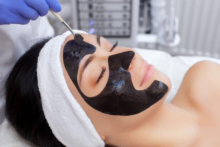 A woman getting her charcoal mask at the salon, How Often Should You Use A Charcoal Mask?