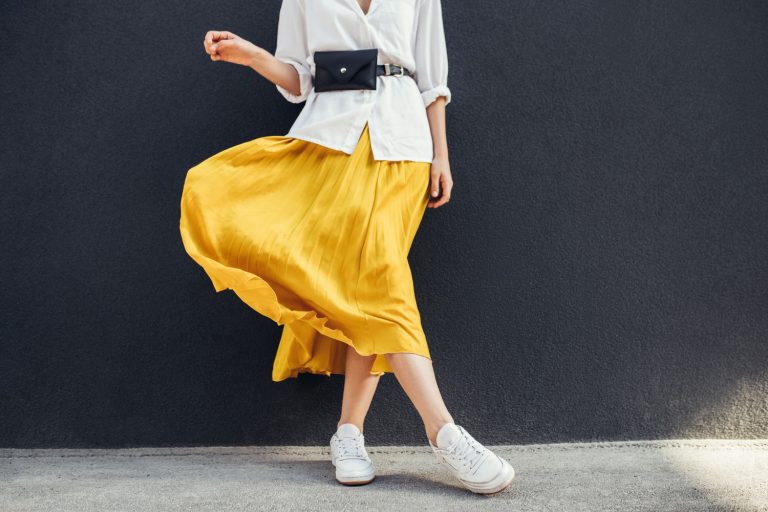 A woman wearing a white blouse and a yellow maxi skirt, Can You Wear Maxi Skirts In The Winter? [11 Outfit Ideas]