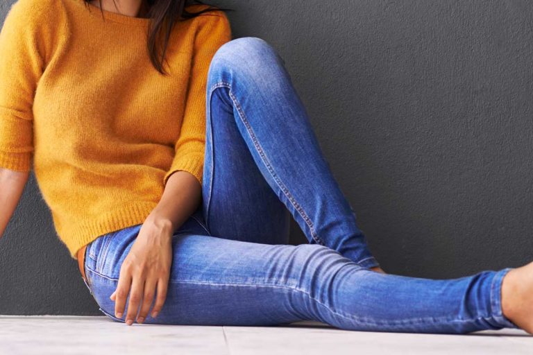 Attractive young woman sitting on the floor wearing jeans, What Tops Go With Skinny Jeans?