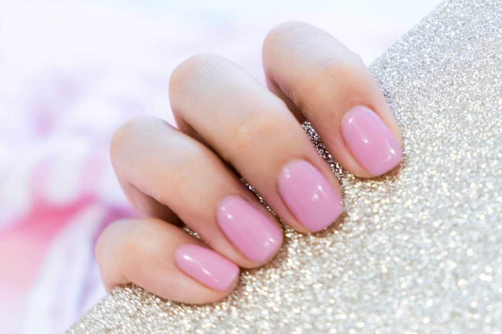 Close up of a female with pink manicured fingernails