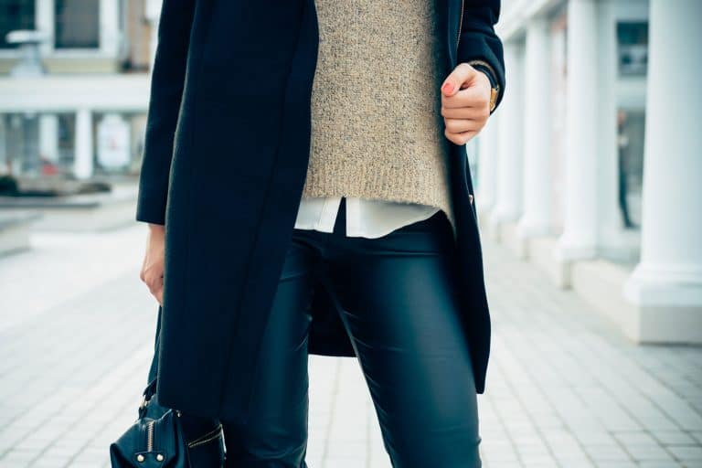 Details of women's clothing. Close-up of a woman in a sweater, coat, black leather pants, How To Style Black Leather Pants [5 Ideas For Men And Women]