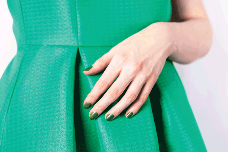 Female hand with green colored nails in green dress. What Color Nails Go With A Green Dress