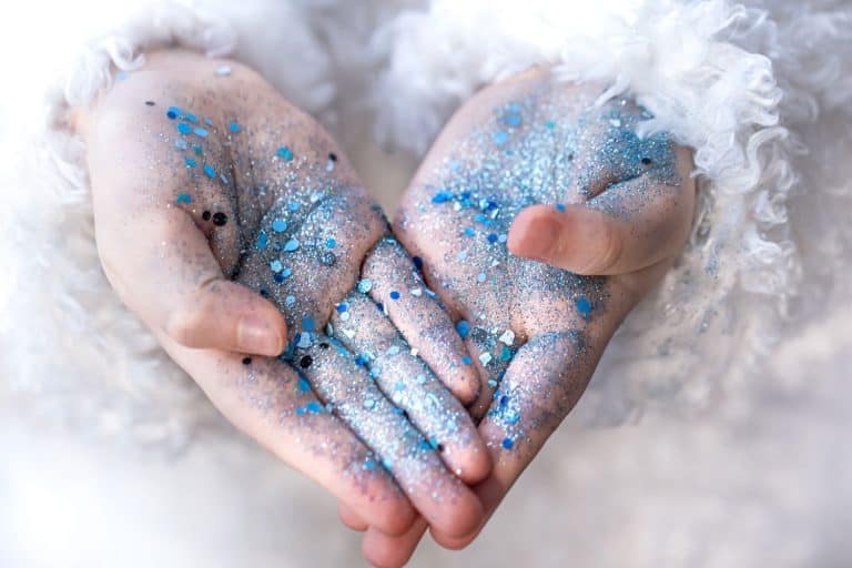 Hands of a little girl in blue sequins, Can You Put Body Glitter In Your Hair?