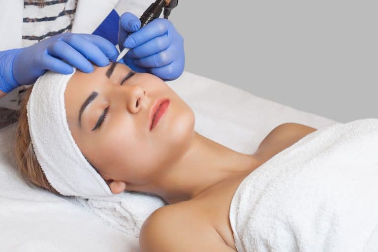 A woman getting her eyebrows done at the dermatologist, Are Microblading Eyebrows Permanent?