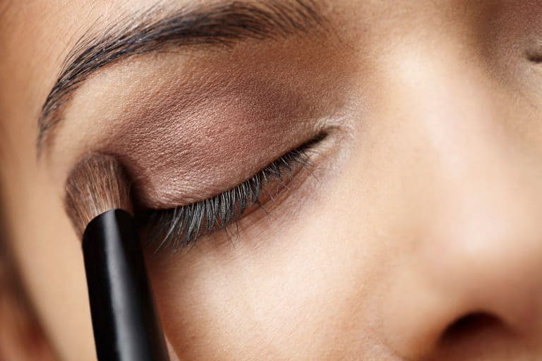 An up close photo of a woman applying brown eyeshadow, What Color Eyeshadow For Brown Eyes And Olive Skin?