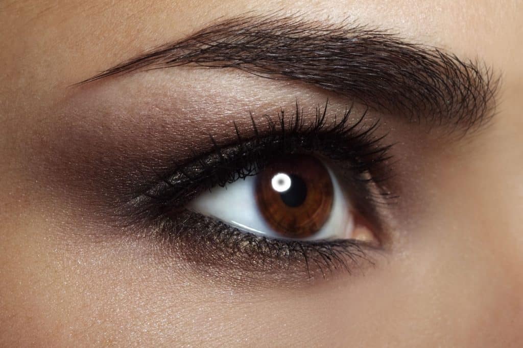 An up close photo of a woman wearing a brown eyeshadow