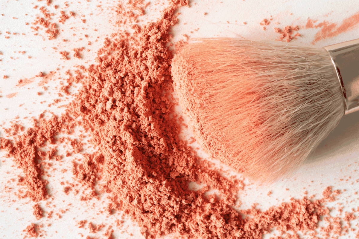 Face blusher powder and make-up brush on white background close-up, top view.