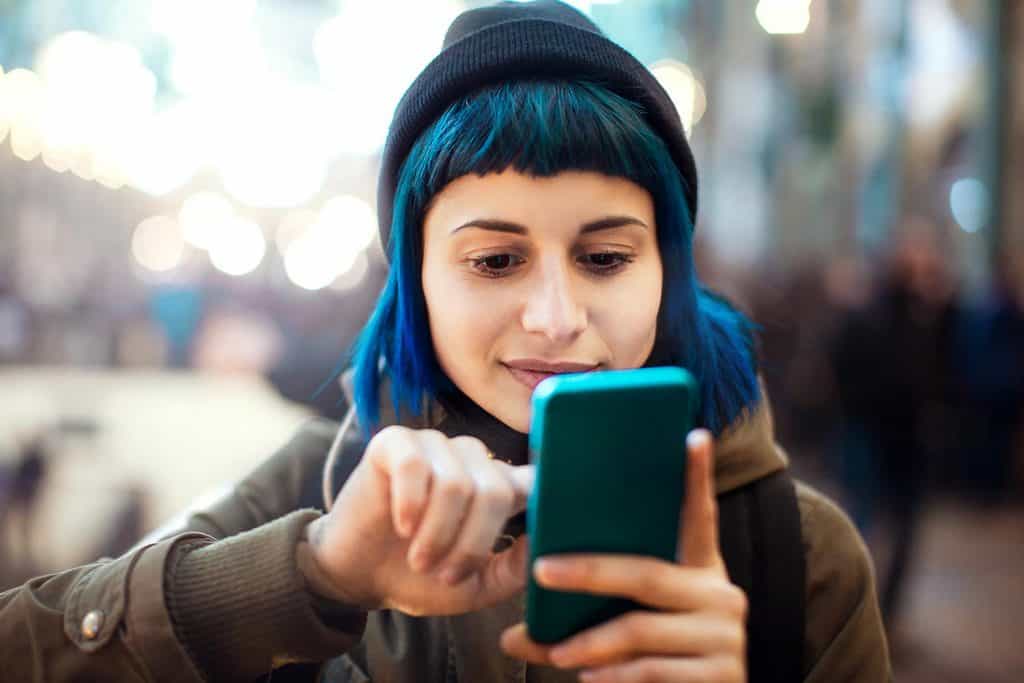 Girl with blue hair using smartphone