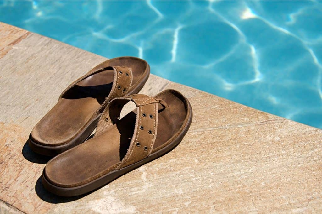 Man's leather flip flop on the edge of the pool
