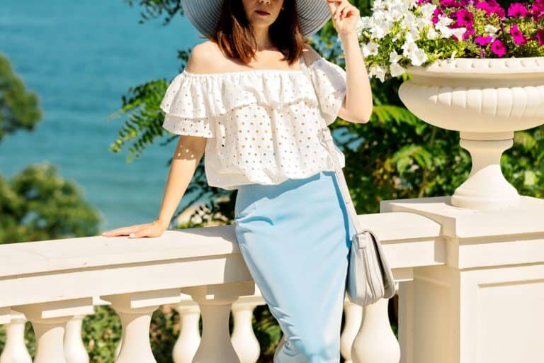 Young woman in a white blouse, blue pencil skirt and hat on a background of the sea horizon, What To Wear Under A Pencil Skirt?