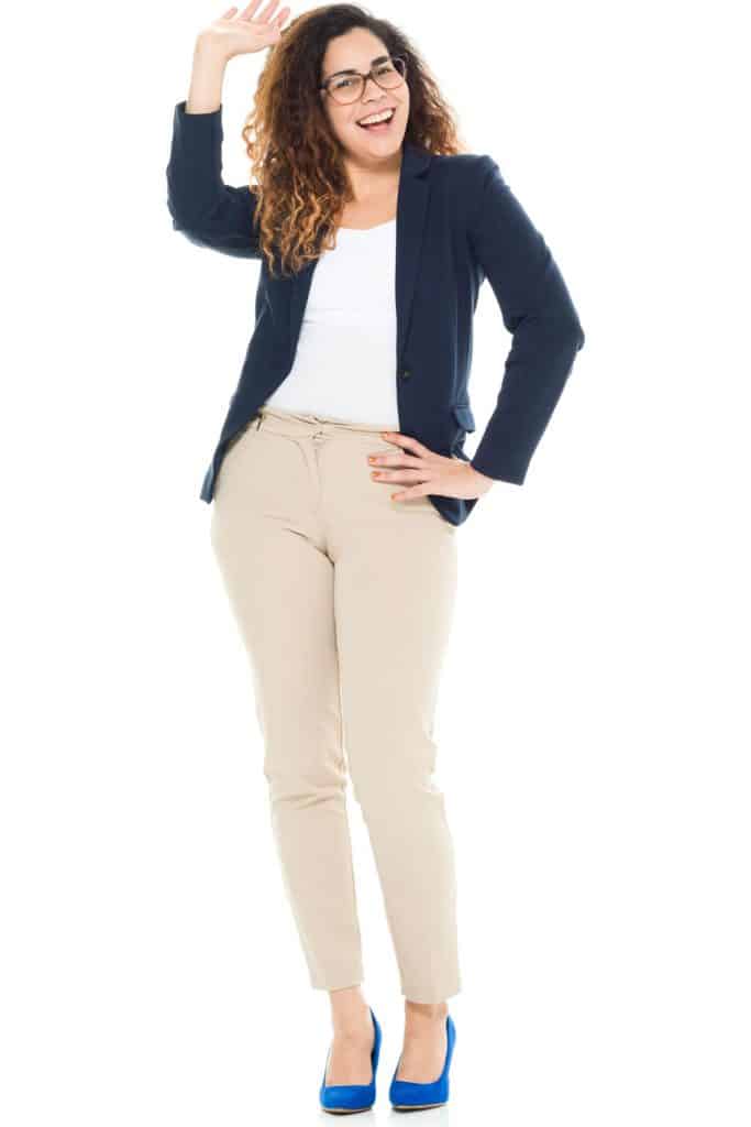 A business woman wearing a blue tux, tan pants, and blue shoes on a white background