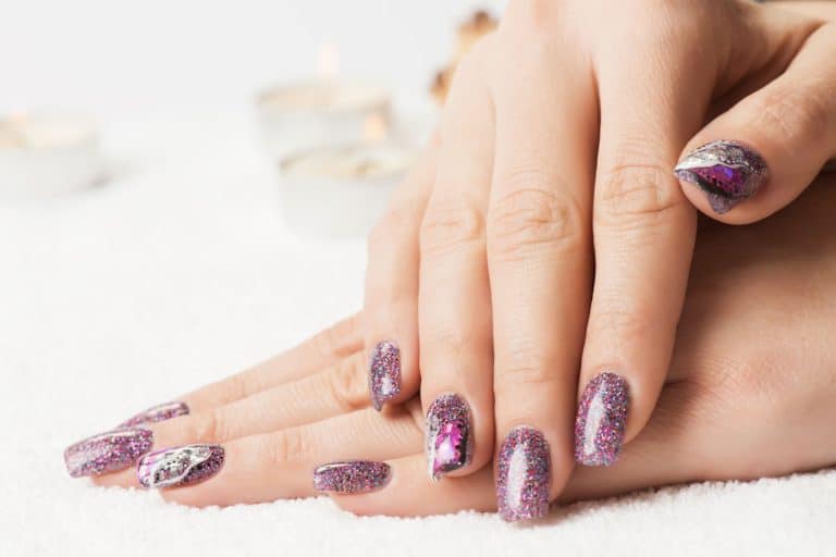 A woman showing her purple glitter designed nails, Can You Use Regular Glitter On Nails?