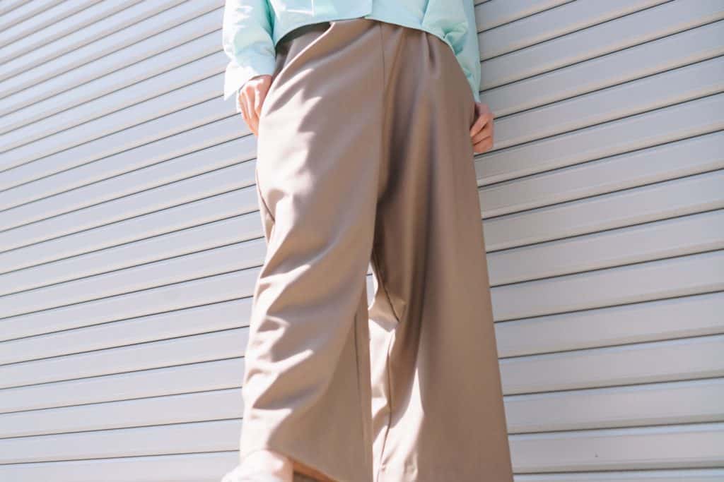 A woman wearing a blue blouse khaki pants and high heeled shoes, How To Wear Tapered Pants - 15 Styling Tips!