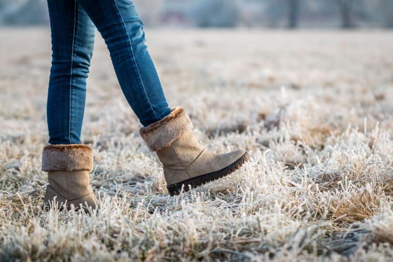 A woman wearing skinny jeans and winter boots walking on the field, Can You Wear Socks With Skinny Jeans?