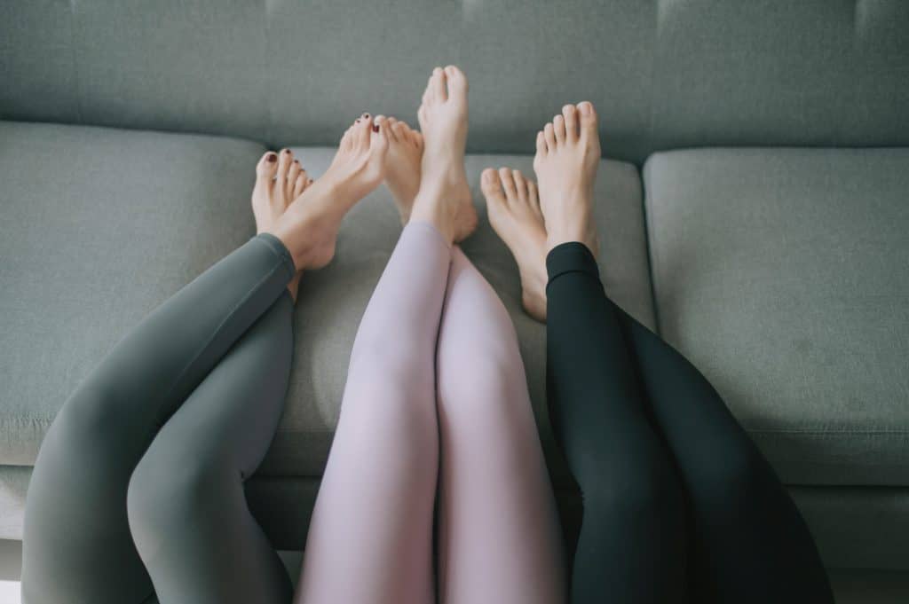 Asian chinese legs with yoga pants resting on sofa legs crossed