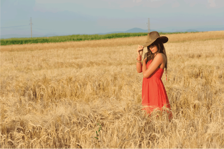 Beautiful woman with orange dress and hat standing in wheat field. What Color Lipstick Goes With An Orange Dress