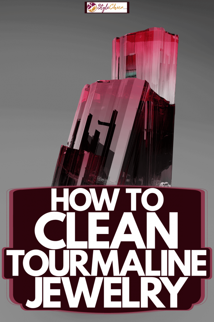 A gorgeous gradient colored formation of a tourmaline crystal on a gray background, How To Clean Tourmaline Jewelry