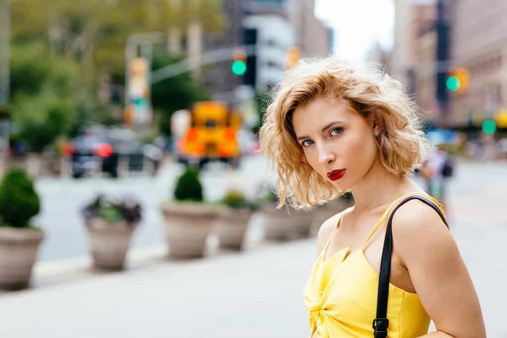 Portrait of a seductive young woman in yellow walking in the city