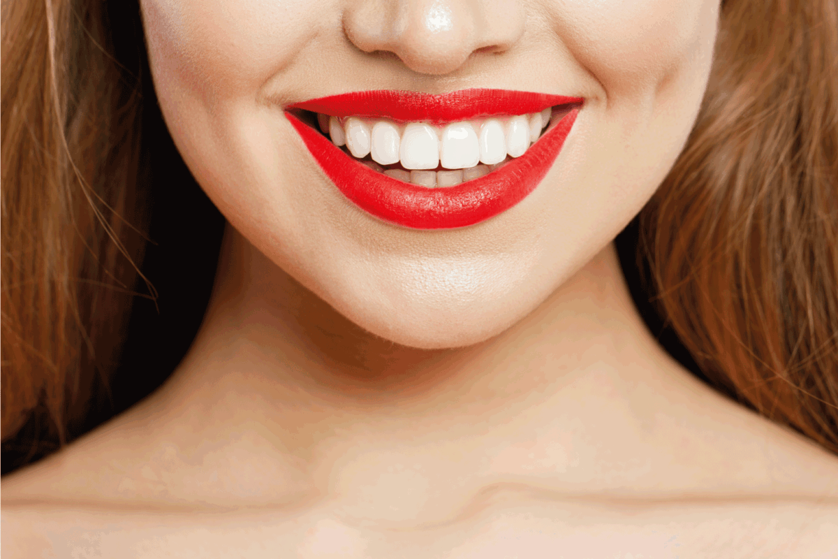 Red makeup Lips with trendy color tint lipstick. Beautiful female smile and perfect white teeth