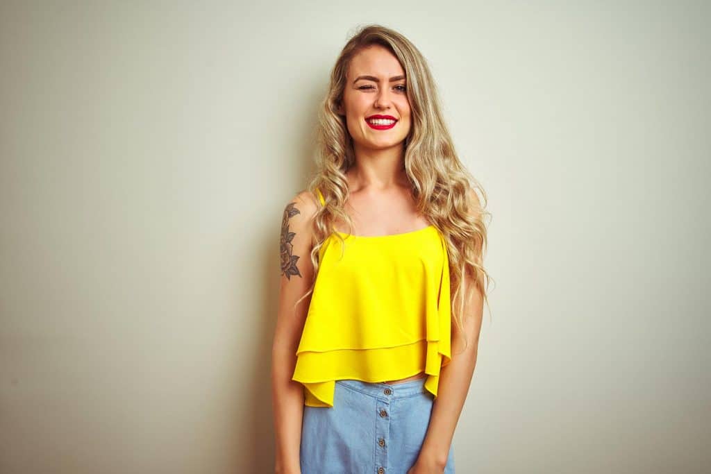 Young beautiful woman wearing yellow t-shirt standing over white isolated background