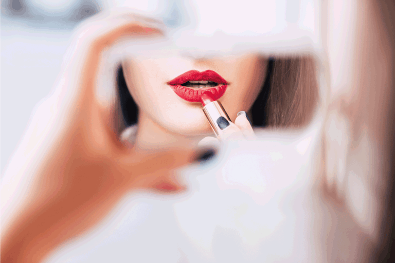 reflection of a woman using mirror wo apply red lipstick. What Color Blush Goes With Red Lipstick