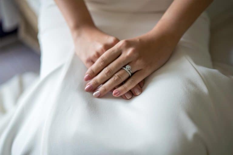 Woman with pink nails dressed in white wedding dress, What Nail Color Goes With A White Dress?