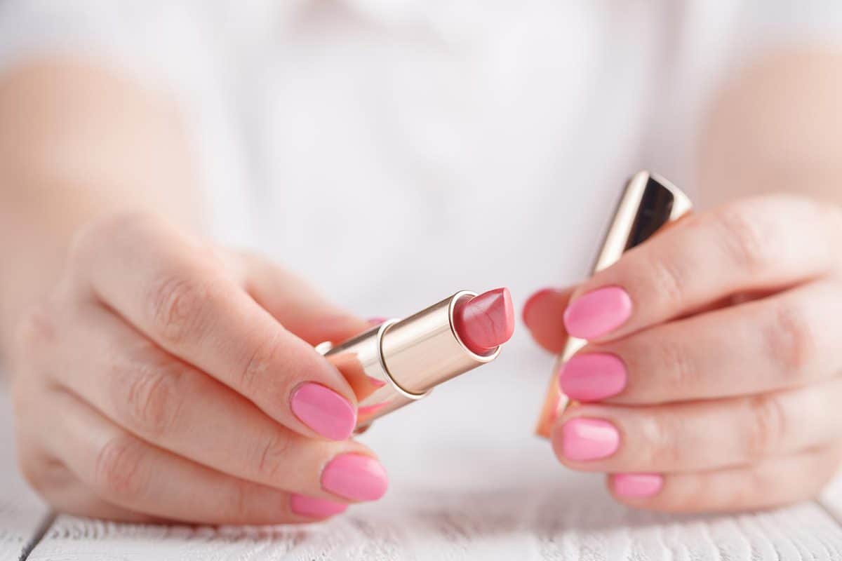 Hand holding pink lipstick
