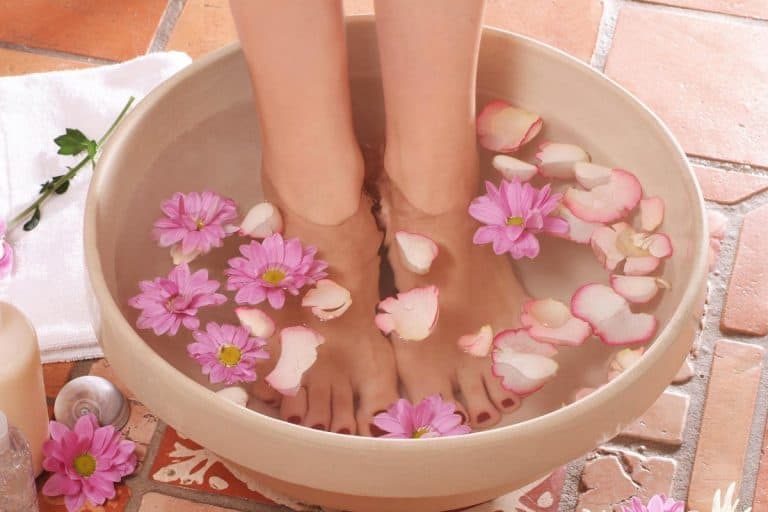 Feet stood in bowl of water with flowers next to lotions, What Is The Best Foot Soak Before A Pedicure?