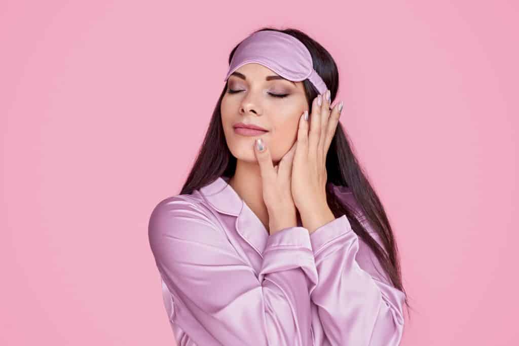 A woman wearing her pink pajamas and pink sleeping mask