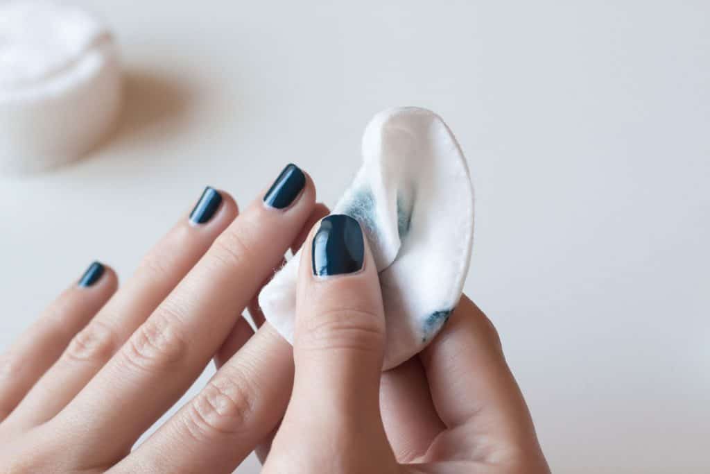 Remove nail polish with acetone and a piece of cotton